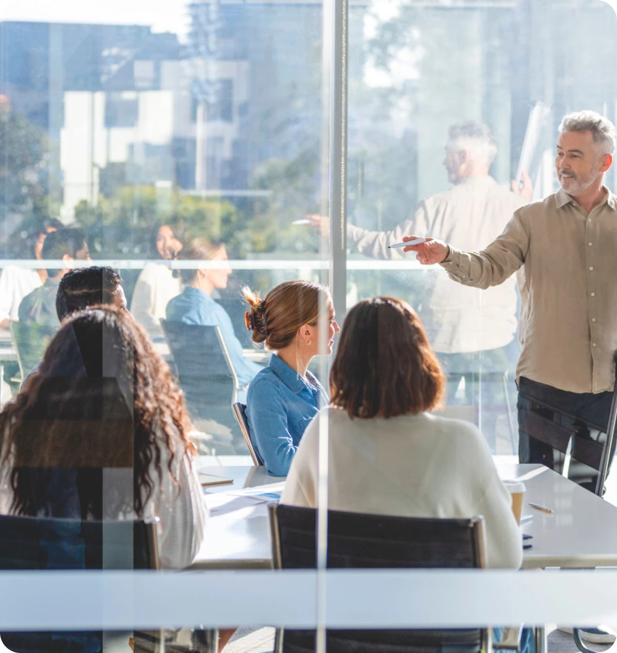 Office meeting with a presenter and attendees.