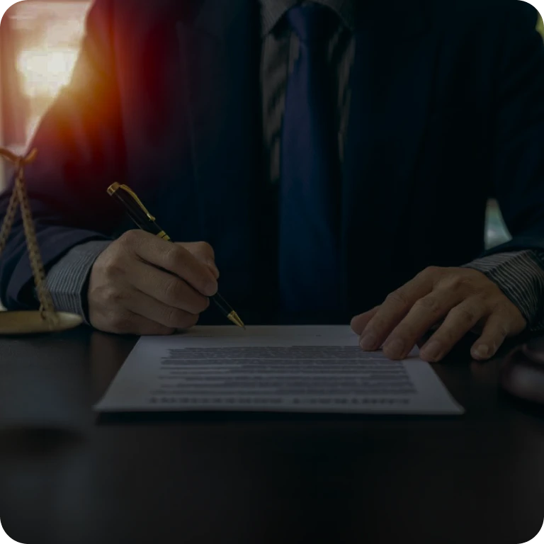 Man signing document at a desk.