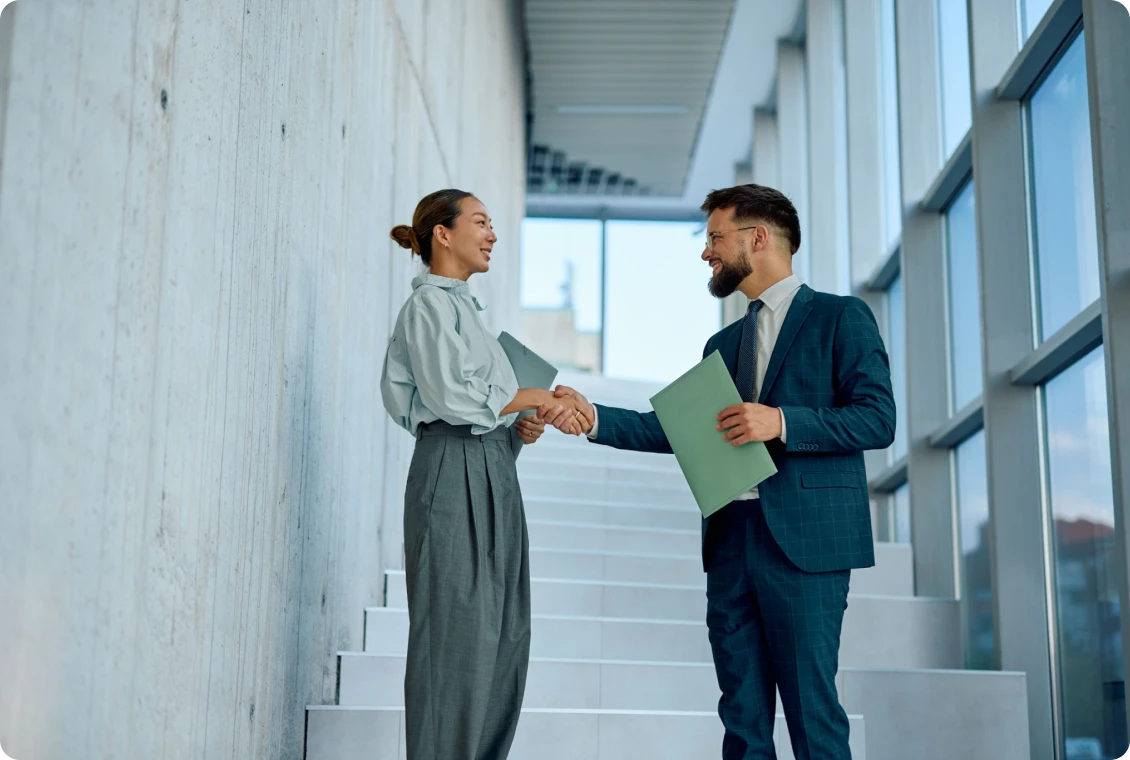 Businesspeople shaking hands on a staircase.
